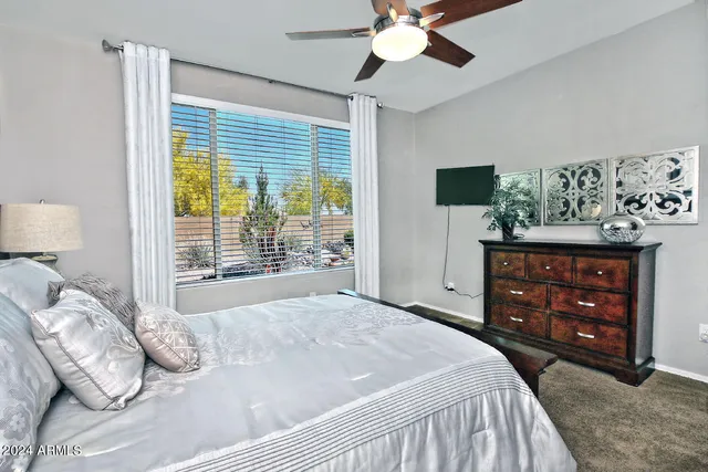 a bedroom with a bed a dresser and a large mirror