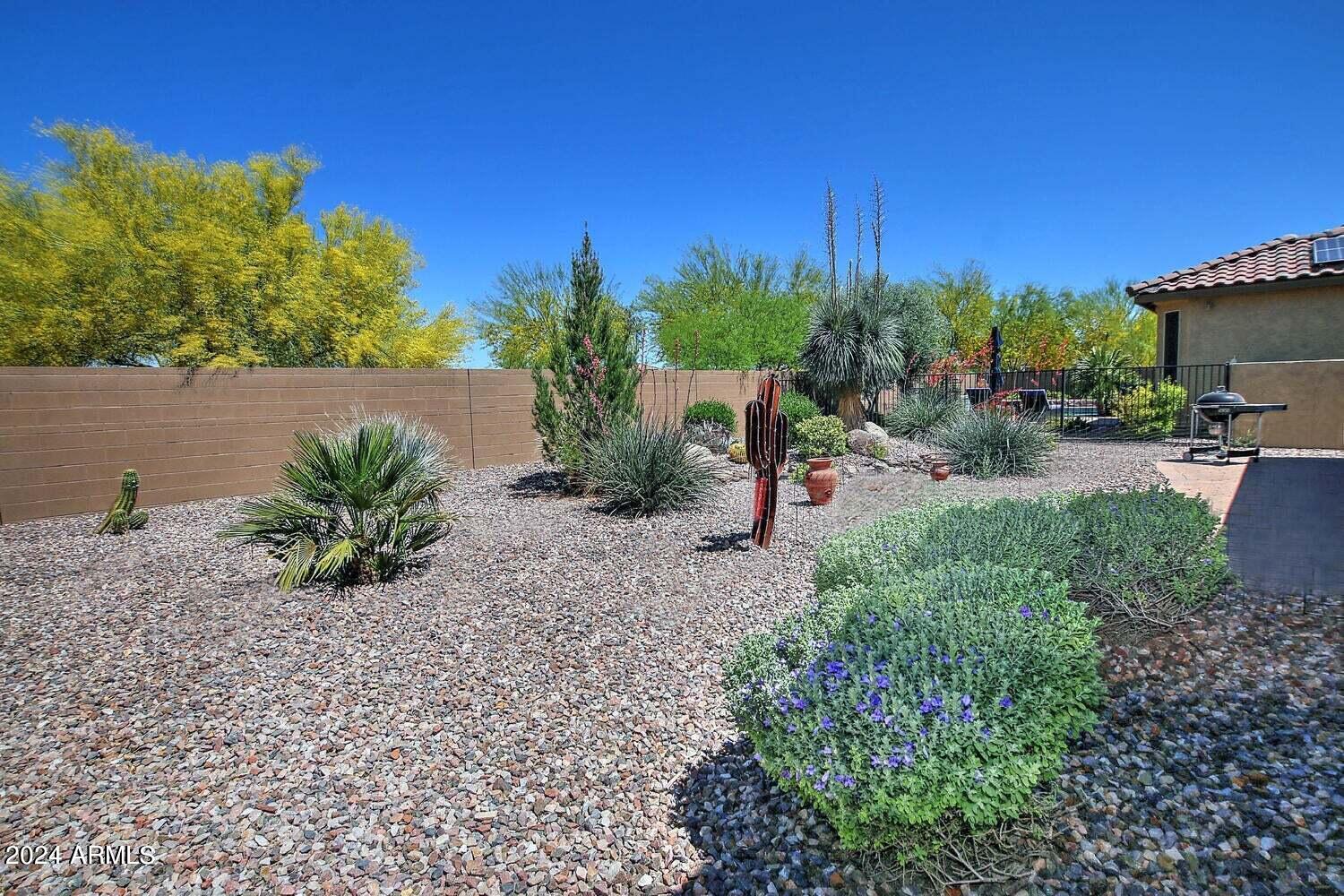 4394 North Hummingbird Drive Florence, AZ 85132 - Photo 29 of 32 a view of a yard with plants and a bench