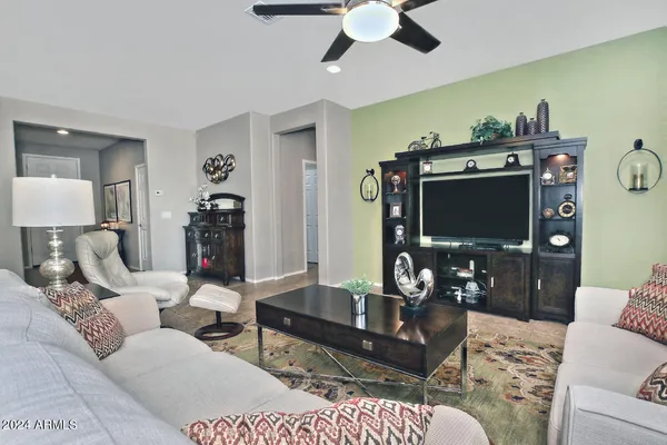 a living room with furniture a flat screen tv and a dining table