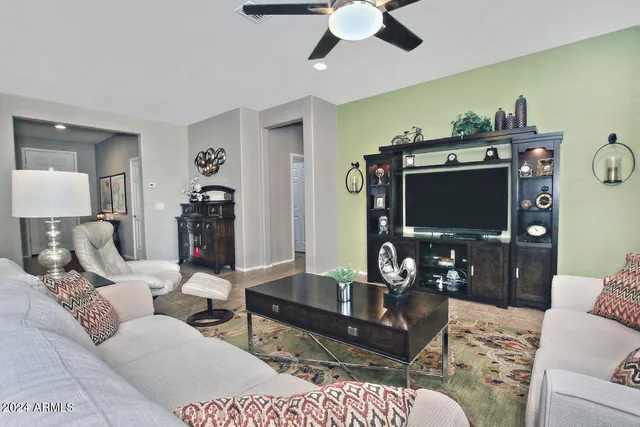a living room with furniture a flat screen tv and a dining table
