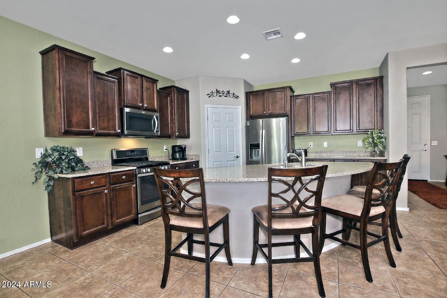 4394 North Hummingbird Drive Florence, AZ 85132 - Photo 10 of 32 a kitchen with stainless steel appliances kitchen island granite countertop a stove a refrigerator a sink a dining table and chairs
