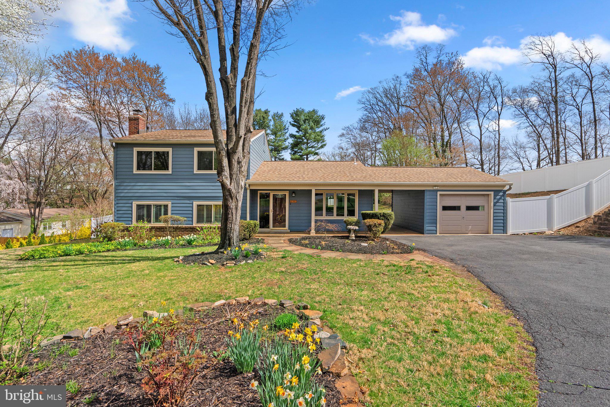 a front view of a house with garden and trees