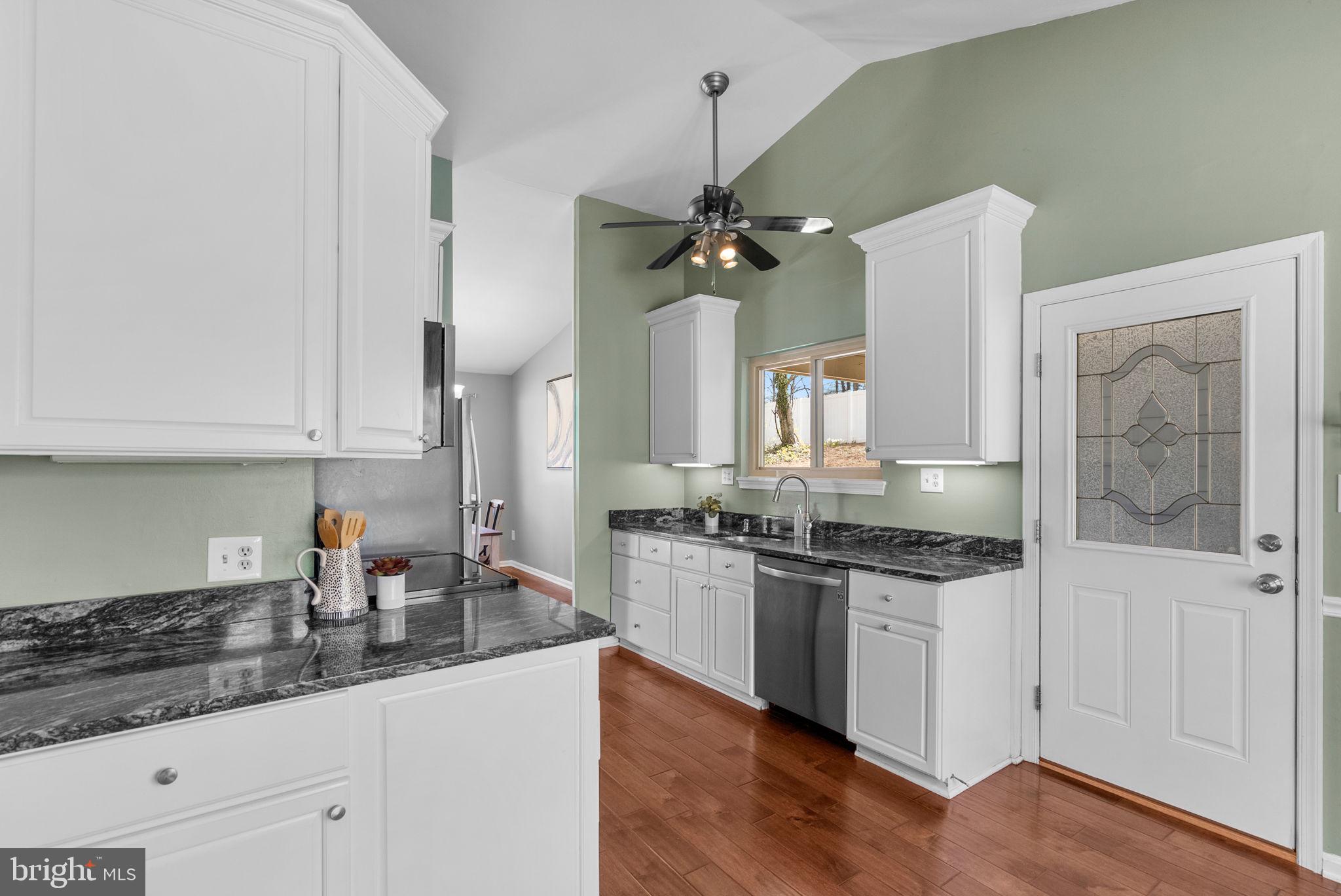 9828 Moyer Road Damascus, MD 20872 - Photo 12 of 46 a kitchen with stainless steel appliances granite countertop a sink cabinets and wooden floor