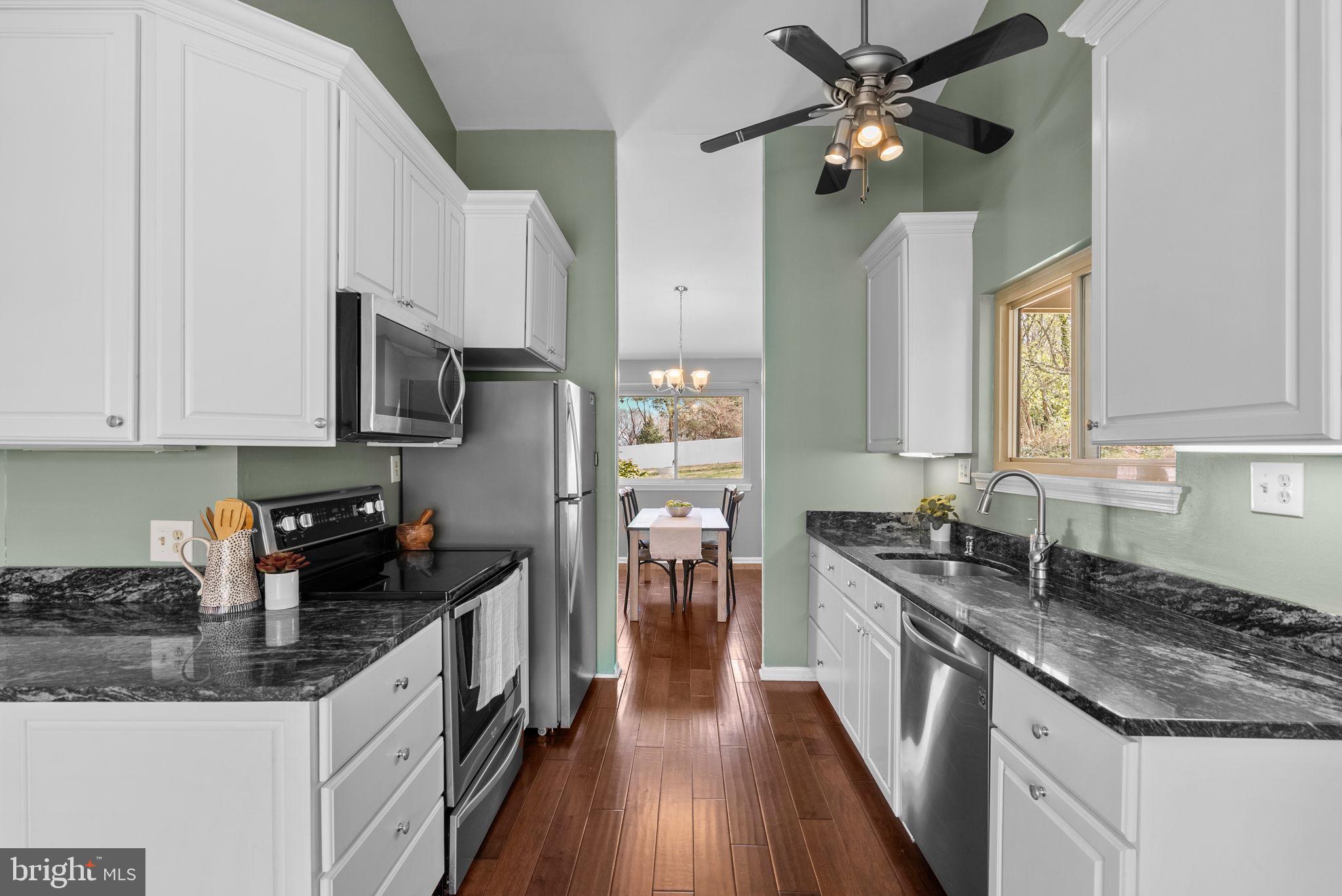 9828 Moyer Road Damascus, MD 20872 - Photo 13 of 46 a kitchen with stainless steel appliances granite countertop a sink stove and refrigerator