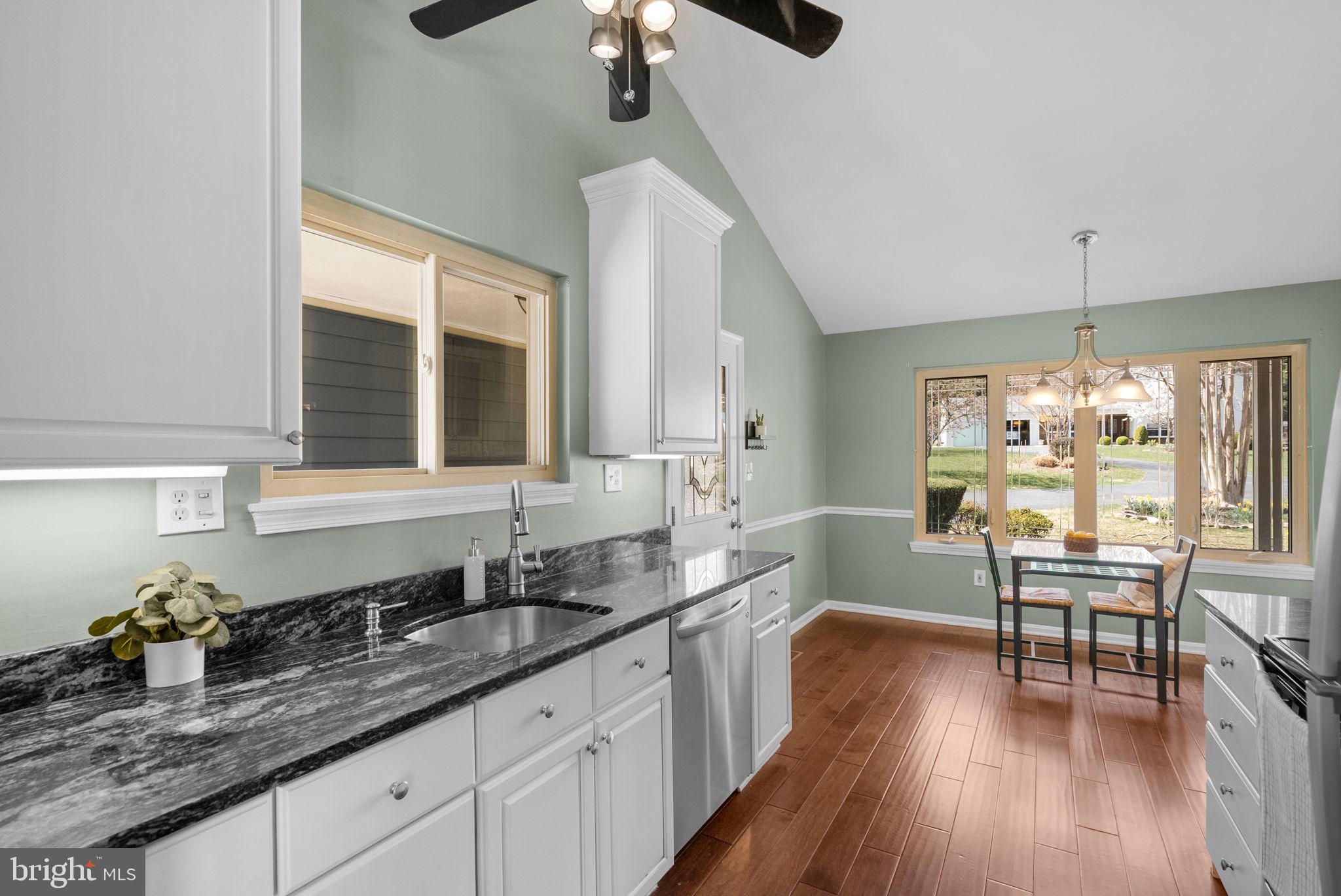 9828 Moyer Road Damascus, MD 20872 - Photo 14 of 46 a kitchen with granite countertop a sink dining table and chairs