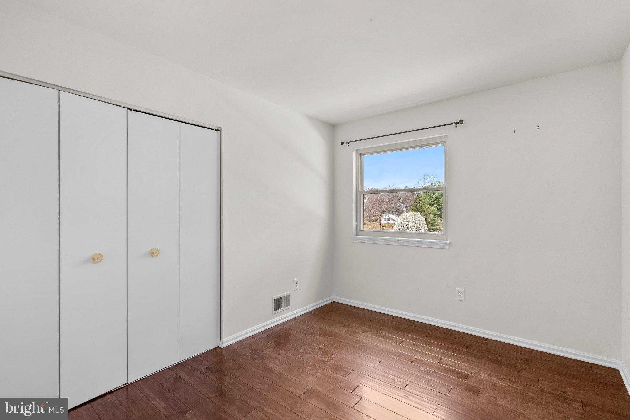 9828 Moyer Road Damascus, MD 20872 - Photo 26 of 46 a view of an empty room with wooden floor and a window