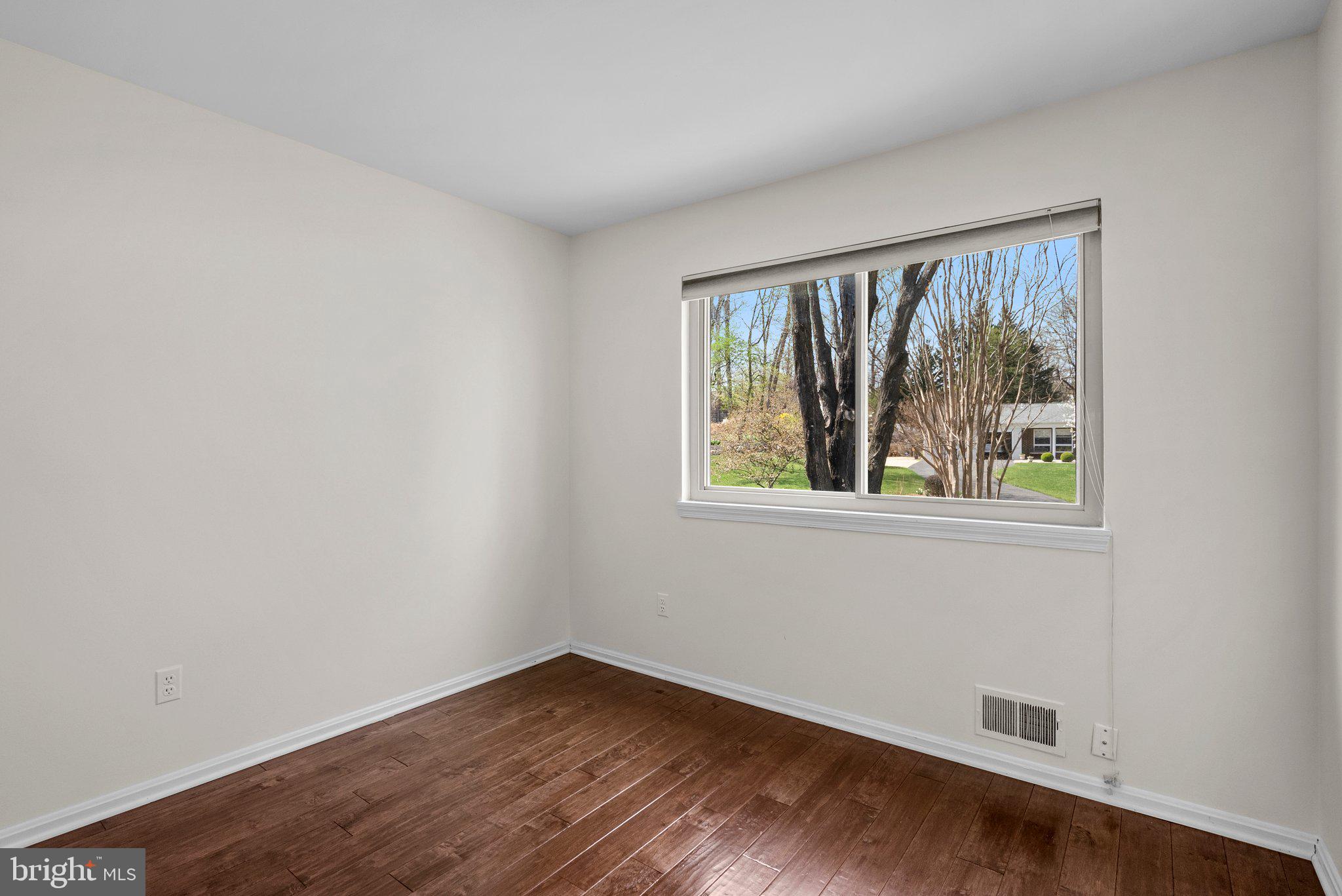 9828 Moyer Road Damascus, MD 20872 - Photo 30 of 46 a view of an empty room with wooden floor and a window