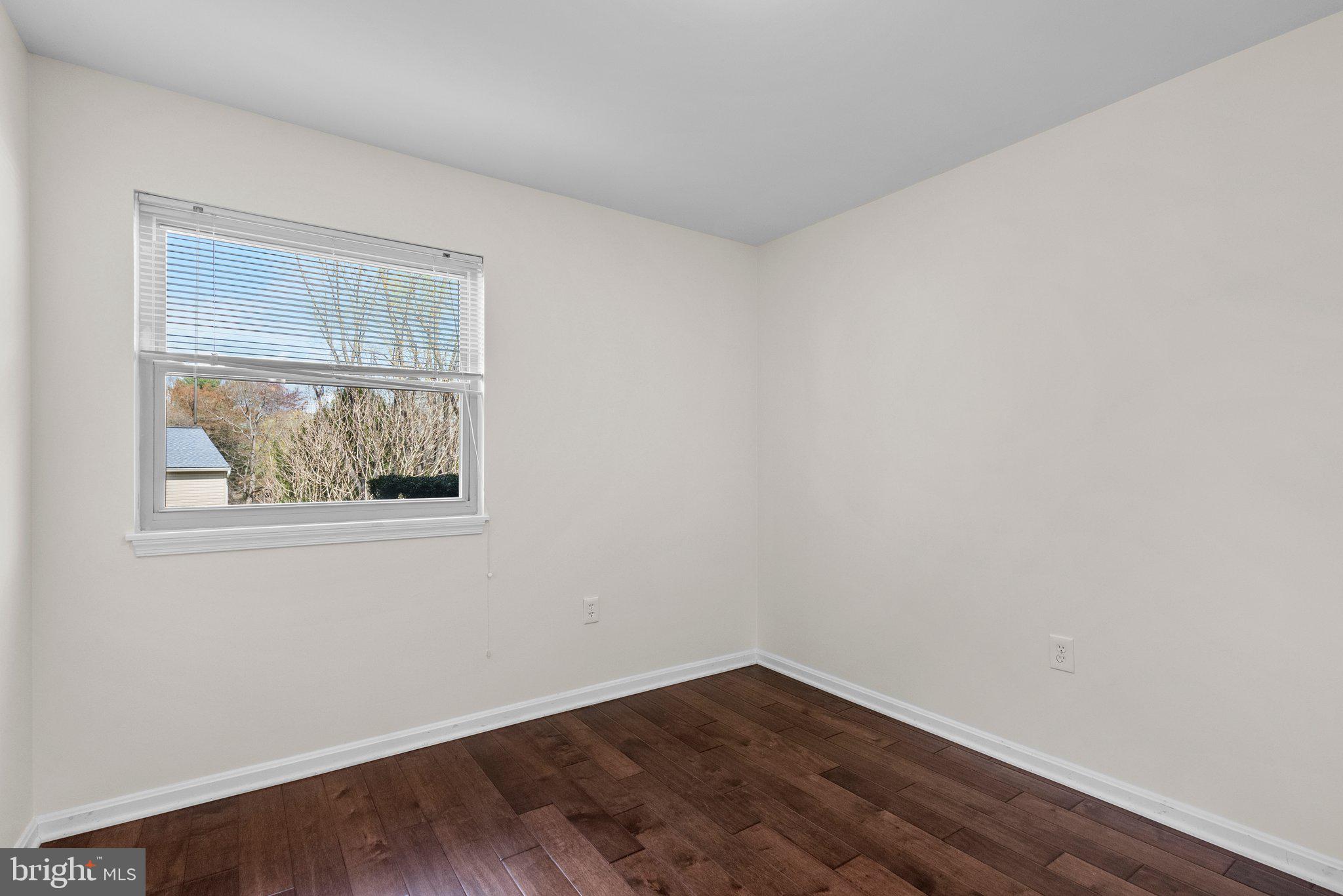 9828 Moyer Road Damascus, MD 20872 - Photo 38 of 46 a view of an empty room with wooden floor and a window