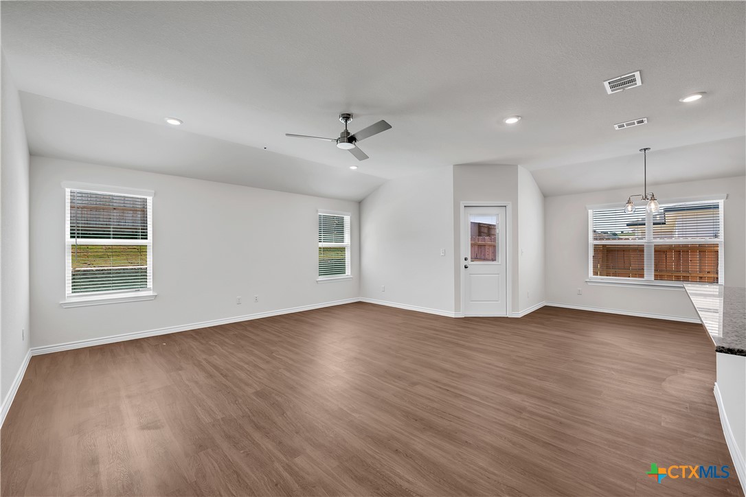 203 Wind Ridge Drive Copperas Cove, TX 76522 - Photo 5 of 16 an empty room with wooden floor chandelier and windows