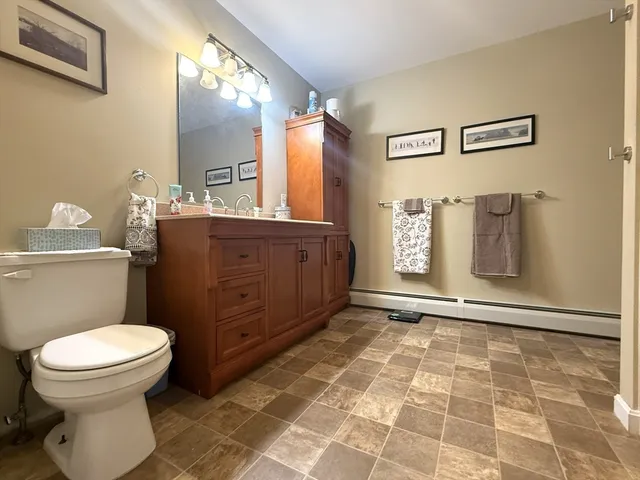 a bathroom with a toilet a sink and mirror
