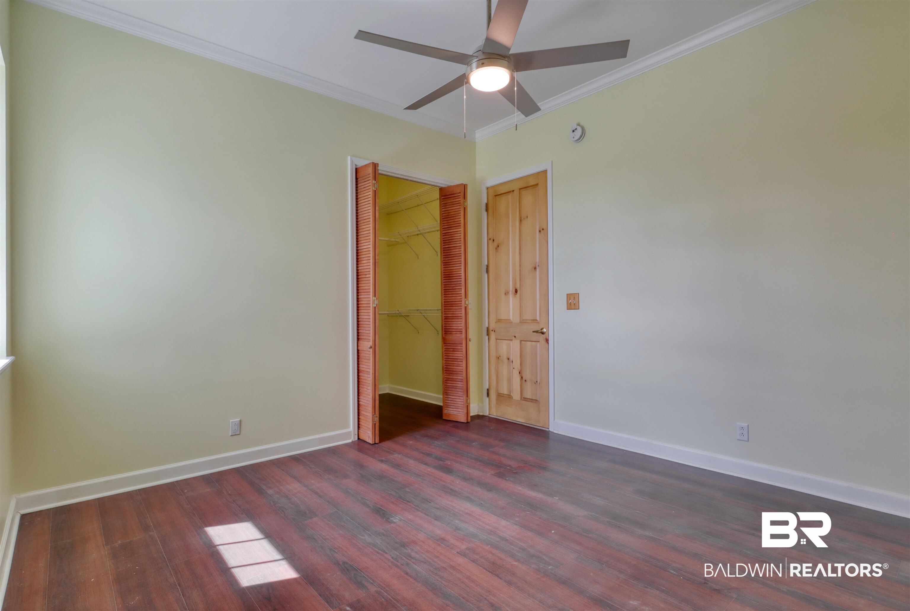 28461 Gardner Road Elberta, AL 36530 - Photo 13 of 46 Unfurnished bedroom featuring crown molding, dark wood-type flooring, and a ceiling fan