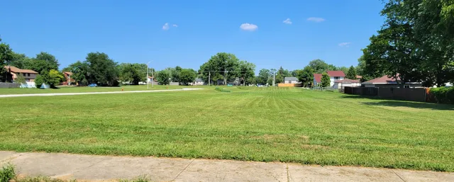 a backyard of a house with lots of green space and outdoor seating