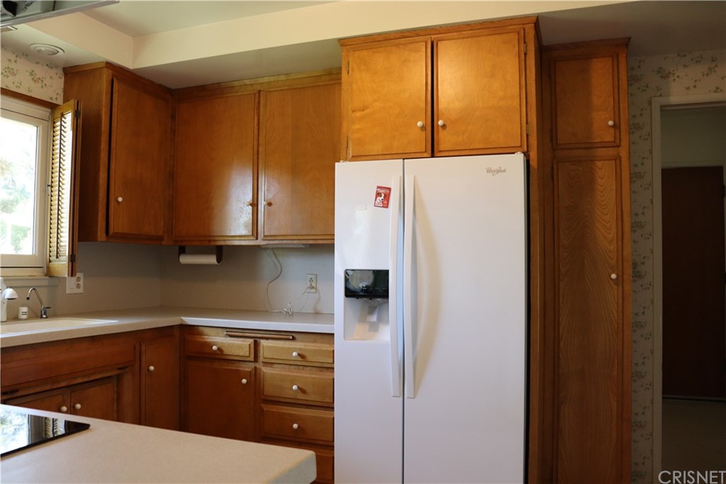 11240 Balcom Avenue Granada Hills, CA 91344 - Photo 9 of 23 a kitchen with a refrigerator sink and cabinets
