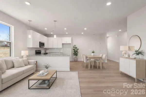 a kitchen with stainless steel appliances granite countertop a stove top oven a sink and white cabinets