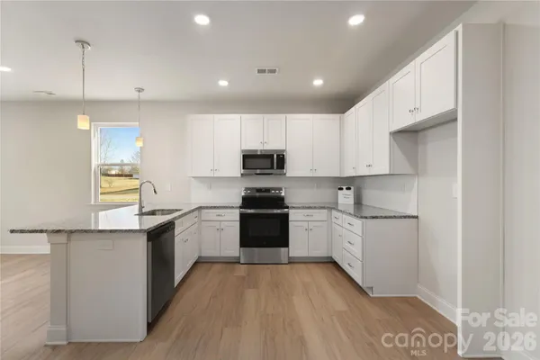 a kitchen with a refrigerator and a stove top oven