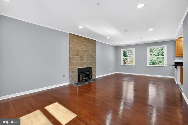 a view of empty room with wooden floor and fireplace