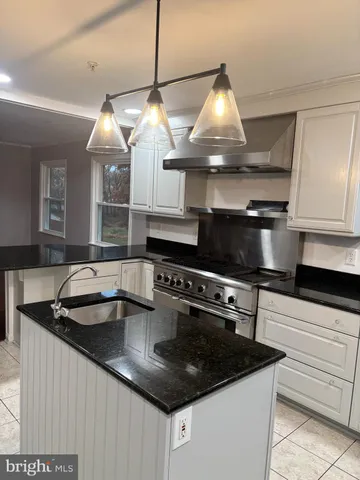 a kitchen with stainless steel appliances granite countertop a sink and a stove