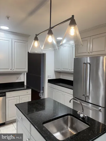 a kitchen with stainless steel appliances granite countertop a sink a refrigerator and a granite counter tops