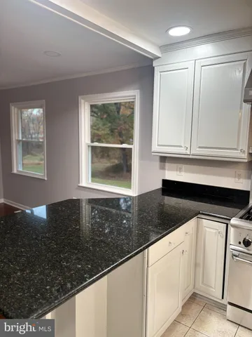 a kitchen with granite countertop white cabinets and sink