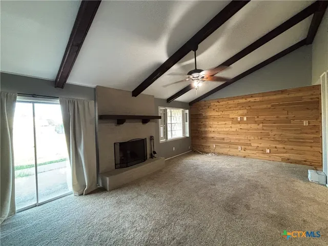 a view of an empty room with a fireplace and a window