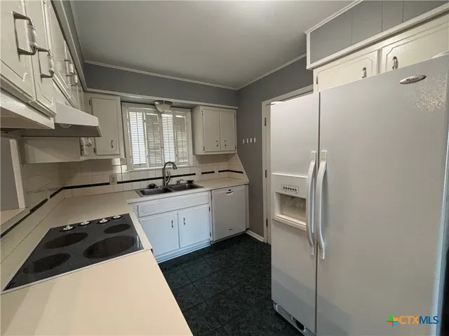 a kitchen with a white cabinets and white appliances