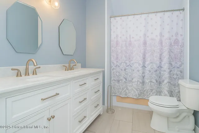 a bathroom with a double vanity sink toilet and a mirror