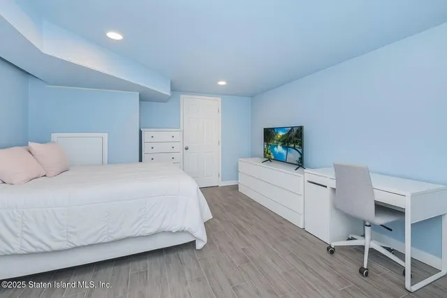 a bedroom with a bed and a flat screen tv