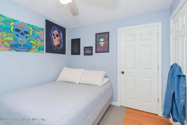 a bedroom with a bed and painting on the wall