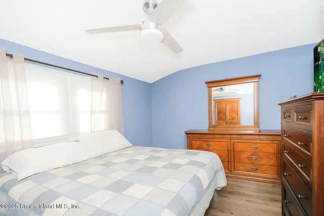 a bedroom with a bed and a flat tv screen on dresser