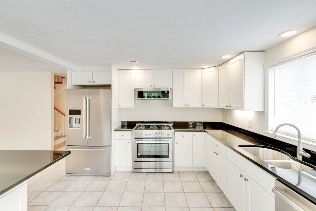 129 Watervale Road, Unit 129 Medford, MA 02155 - Photo 1 of 29 a kitchen with granite countertop a stove sink and refrigerator