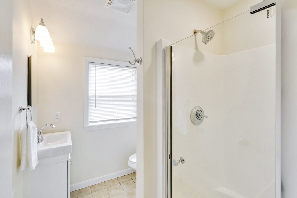 129 Watervale Road, Unit 129 Medford, MA 02155 - Photo 14 of 29 a bathroom with a granite countertop shower a toilet and a sink