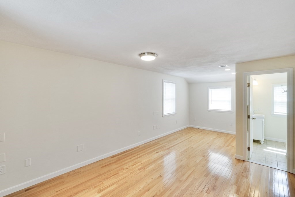129 Watervale Road, Unit 129 Medford, MA 02155 - Photo 15 of 29 an empty room with wooden floor and windows