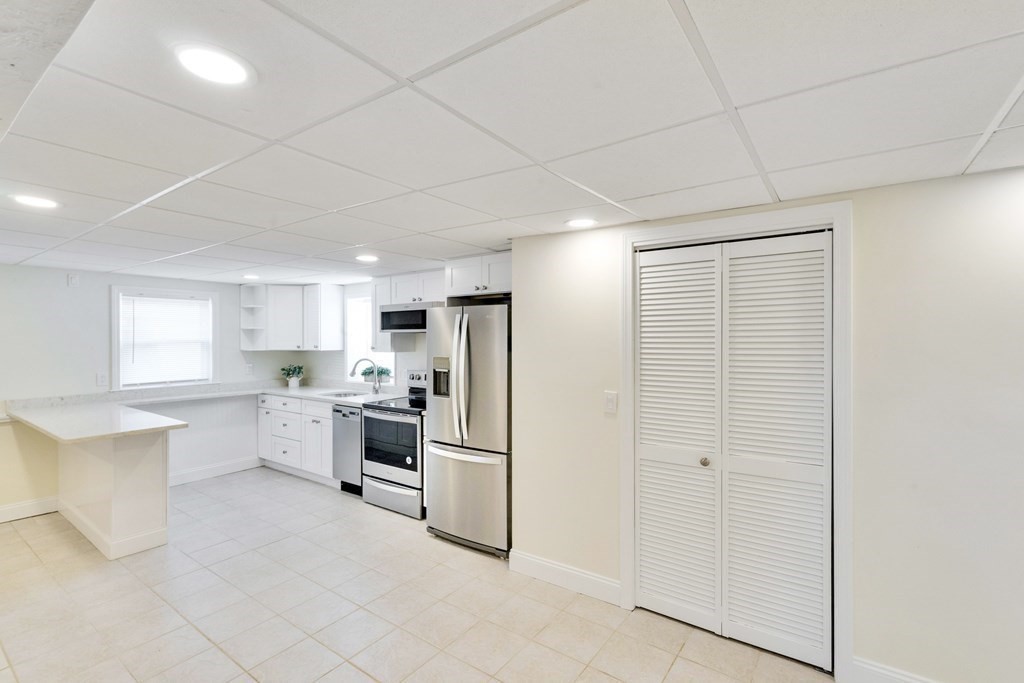 129 Watervale Road, Unit 129 Medford, MA 02155 - Photo 20 of 29 a kitchen with white cabinets and stainless steel appliances