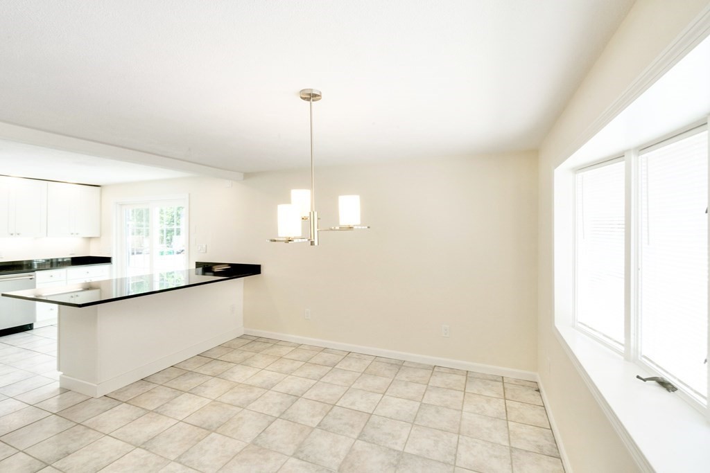 129 Watervale Road, Unit 129 Medford, MA 02155 - Photo 6 of 29 a kitchen with granite countertop white cabinets and a sink