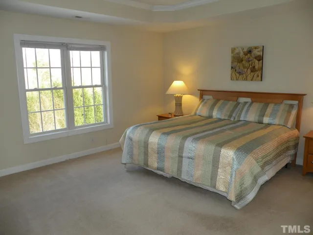 a large bed sitting in a bedroom next to a window
