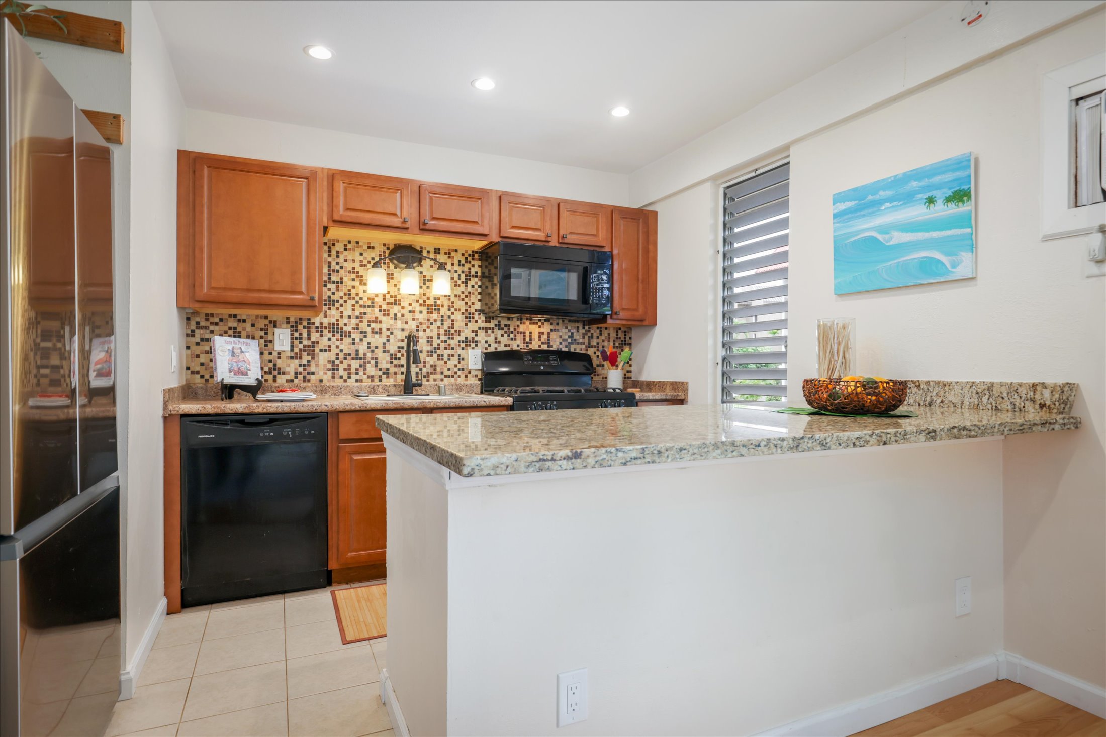 75-5873 Walua Road, Unit 312 Kailua-Kona, HI 96740 - Photo 4 of 15 a kitchen with stainless steel appliances granite countertop a stove and a refrigerator