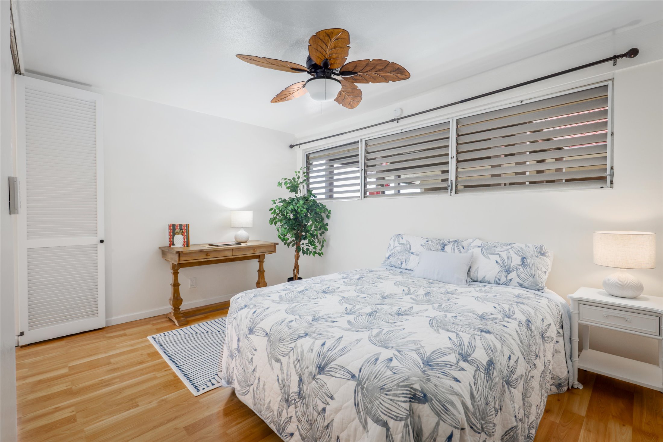 75-5873 Walua Road, Unit 312 Kailua-Kona, HI 96740 - Photo 8 of 15 a bedroom with a bed and a chandelier