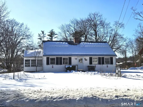 a front view of a house with a yard covered in snow