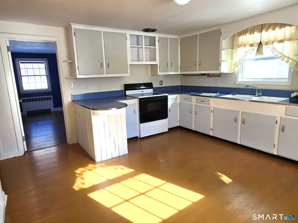 a kitchen with stainless steel appliances granite countertop a stove a sink and a granite counter tops with a large window