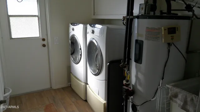 a utility room with wooden floor washer and dryer