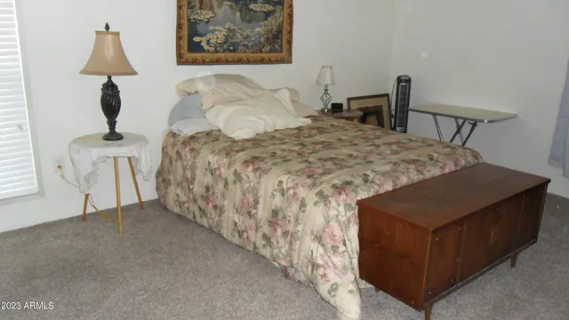 a bedroom with a bed and a lamp on table