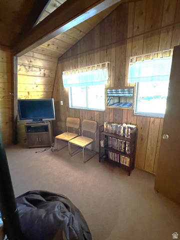 1456 Navajo Road Coalville, UT 84017 - Photo 32 of 55 Carpeted living room featuring wooden walls and vaulted ceiling with beams