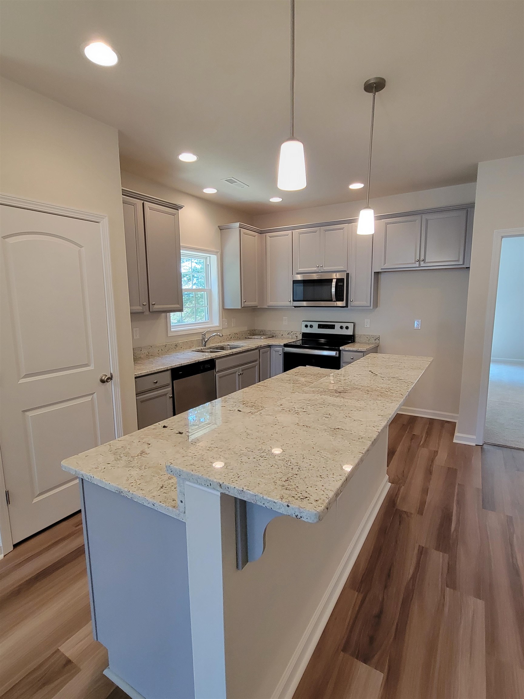 902 New Hope Road Staunton, VA 24401 - Photo 2 of 9 a kitchen with kitchen island a stove a sink a refrigerator and a oven with wooden floor