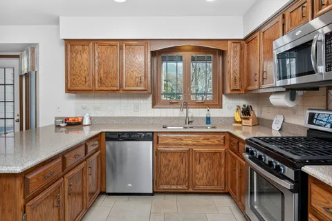 a kitchen with stainless steel appliances granite countertop a sink stove and cabinets