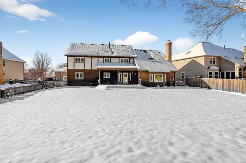 a front view of a building with a yard and a car parked in front of it