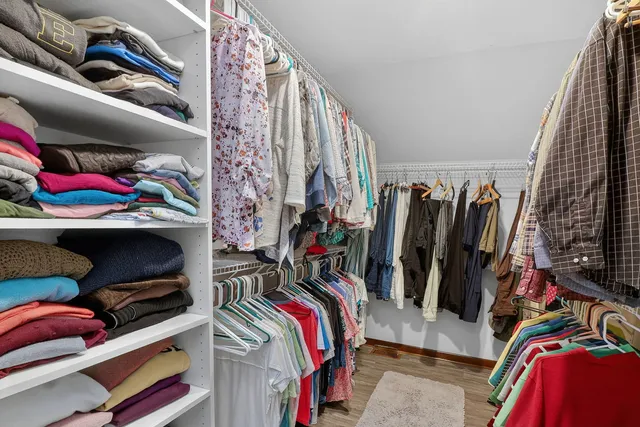 a view of walk in closet with clothes and shoes