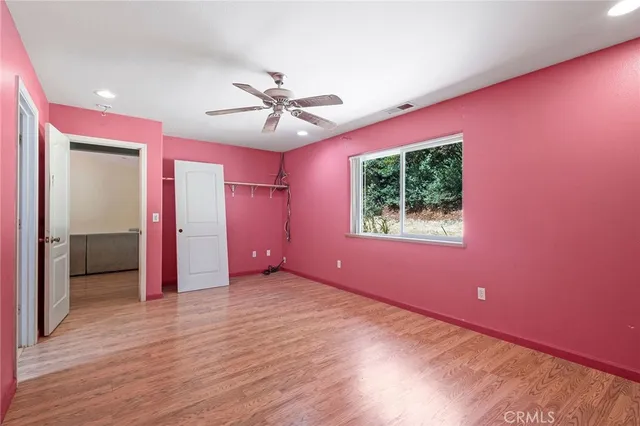 an empty room with a window and a fan
