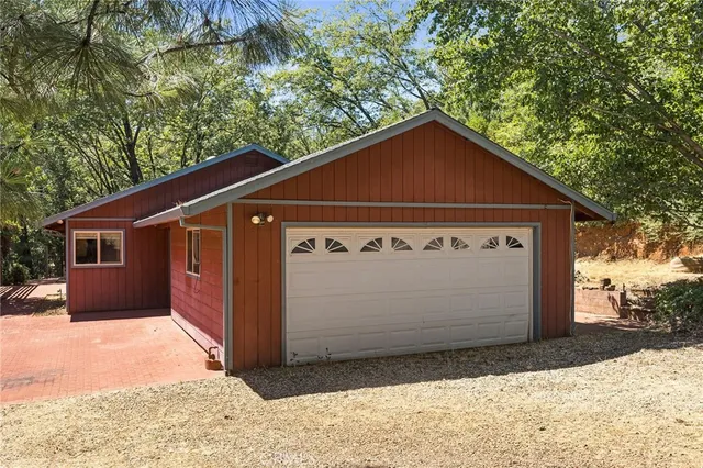 a view of a backyard with a large tree and wooden fence