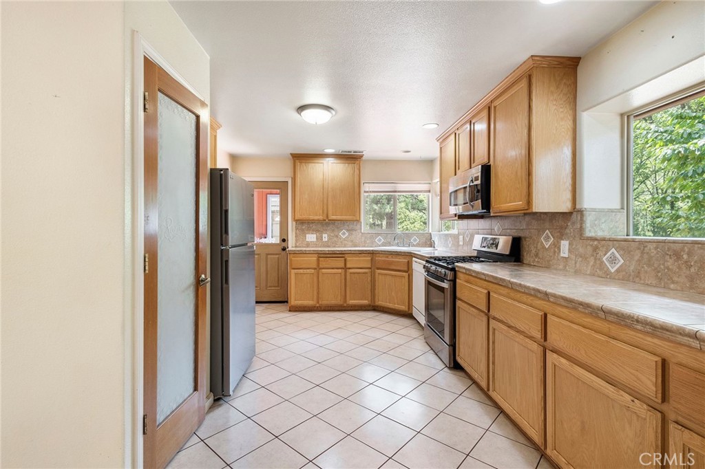 4940 Papya Road Forest Ranch, CA 95942 - Photo 6 of 67 a kitchen with stainless steel appliances granite countertop a refrigerator sink and cabinets