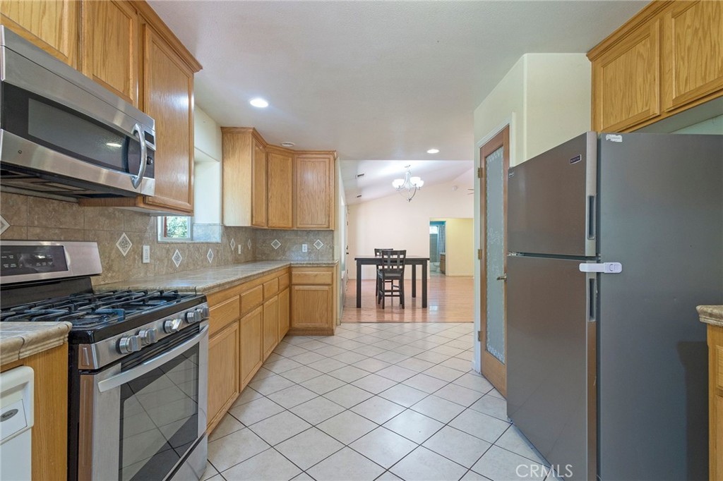 4940 Papya Road Forest Ranch, CA 95942 - Photo 9 of 67 a kitchen with granite countertop a refrigerator and a stove top oven